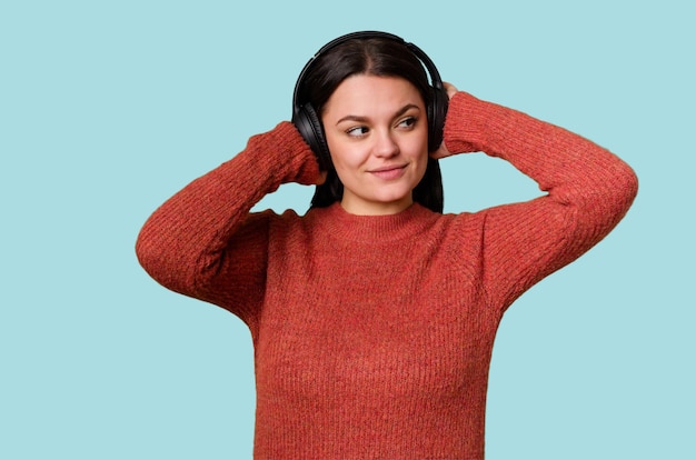 Una mujer escucha música a través de auriculares sintiendo y disfrutando el sonido Está relajada