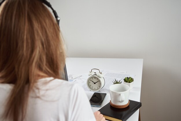 Mujer escuchando curso online en los auriculares, educación a distancia