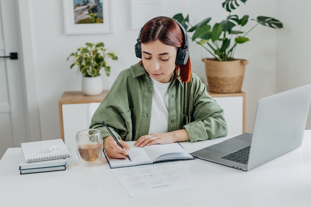 Mujer escuchando música con auriculares inalámbricos Joven estudiante descansando durante la educación