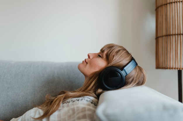 Mujer escuchando música en casa durante la pandemia de coronavirus