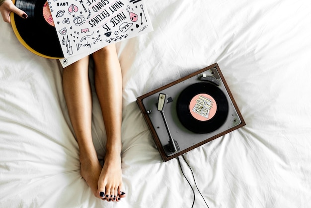 Mujer escuchando música con disco giratorio de vinilo.