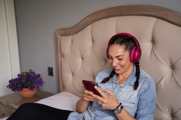 Foto mujer escuchando musica em seu smartphone con auriculares