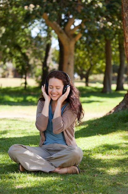 Mujer escuchando música en el jardín.