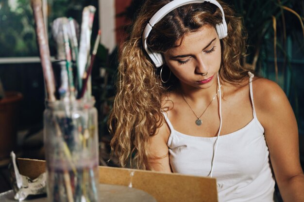 Foto mujer escuchando música mientras está sentada en casa