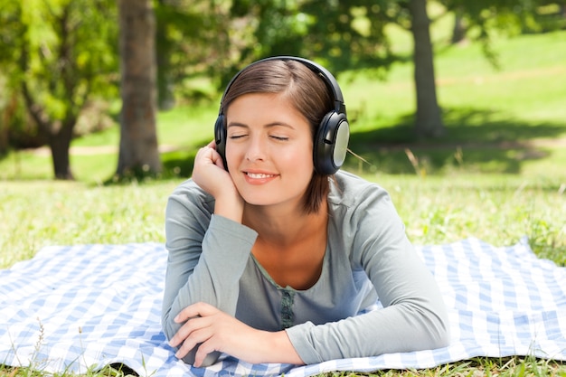 Mujer escuchando música en el parque