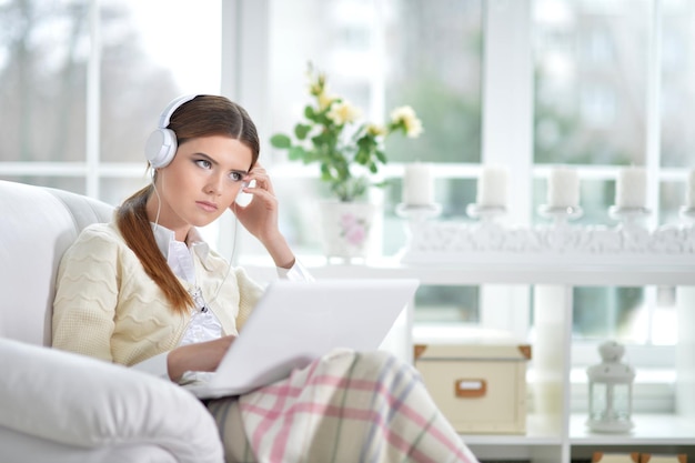 Mujer escuchando música en el sofá