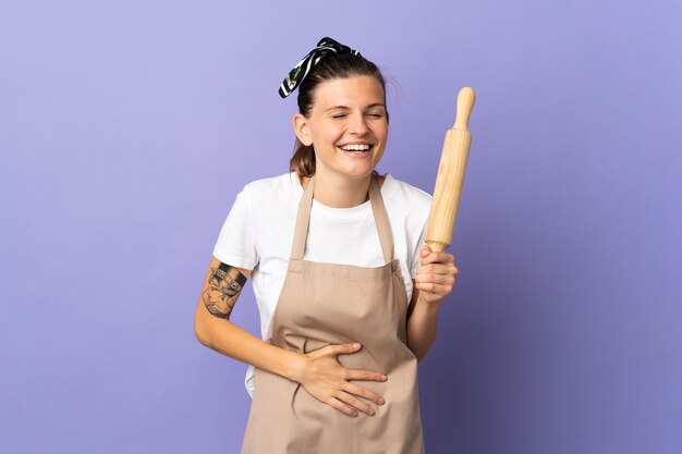 Mujer eslovaca de cocina aislada en la pared púrpura sonriendo mucho