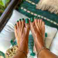 Foto una mujer con esmalte de uñas verde en los dedos de los pies
