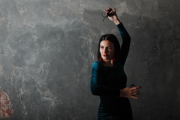 Mujer española adulta joven bailando flamenco sobre fondo gris vintage