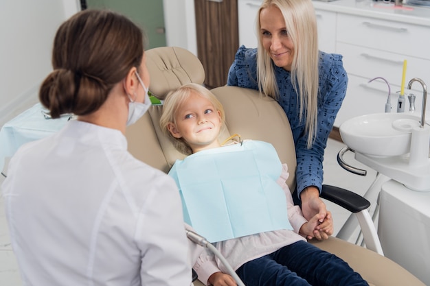 Una mujer especialista dental revisando los resultados del chequeo oral de la niña