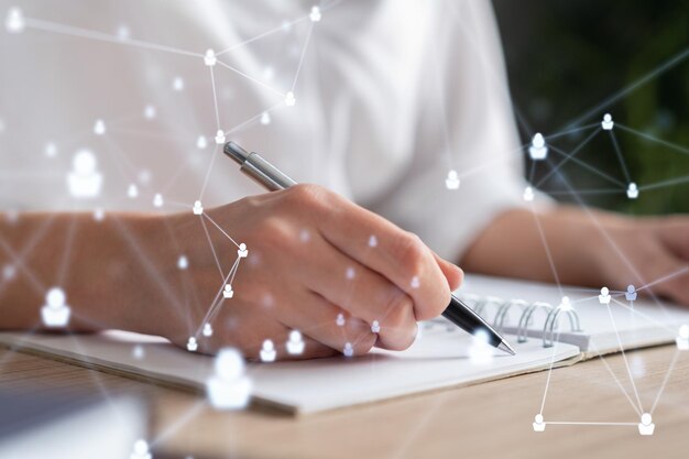Mujer especialista en recursos humanos está tomando notas sobre nuevos candidatos para crear una red internacional en el proceso de contratación Concepto de éxito Iconos de holograma de redes sociales Ropa formal