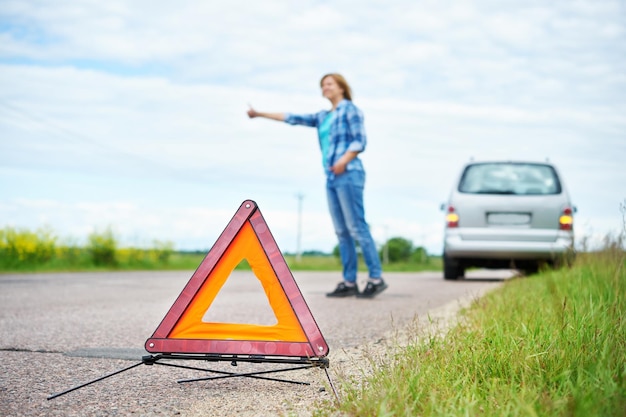 Mujer espera ayuda cerca de coche roto