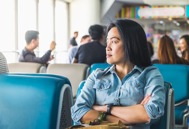 Mujer esperando el vuelo en la terminal del aeropuerto