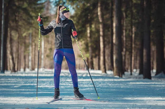 Mujer de esquí de fondo haciendo esquí de fondo nórdico clásico en pistas de senderos en bosques cubiertos de nieve Pista de entrenamiento para esquiadores en el parque de Moscú Odintsovo