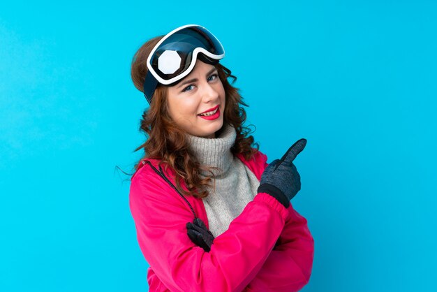 Mujer esquiador con gafas de snowboard sobre pared aislada