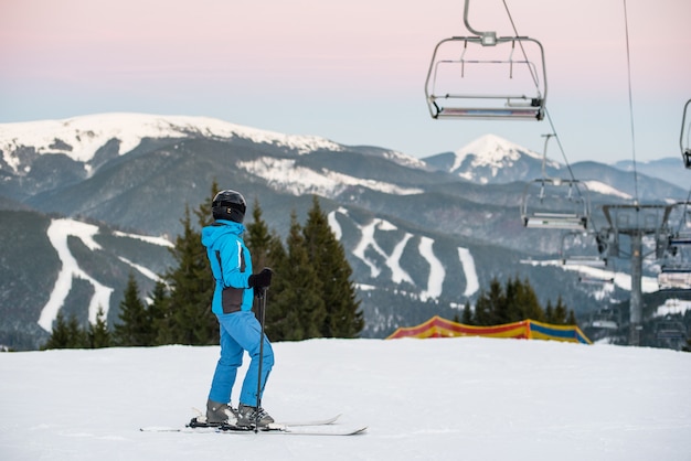 Mujer esquiador en ladera en las montañas del complejo invernal