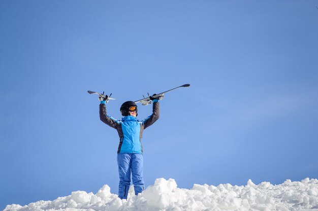 Mujer esquiadora en la cima de la montaña. Concepto de deportes de invierno