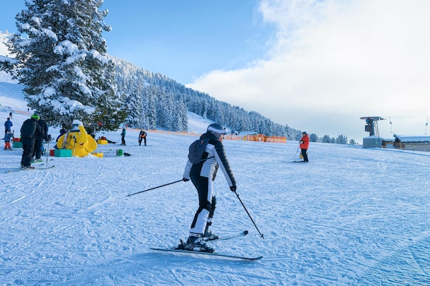 Mujer esquiadora esquiando en la estación de esquí Zillertal Arena en Tirol en Mayrhofen en Austria en los Alpes invernales. Lady Ski en montañas alpinas con nieve blanca y cielo azul. Diversión cuesta abajo en las pistas nevadas de Austria.