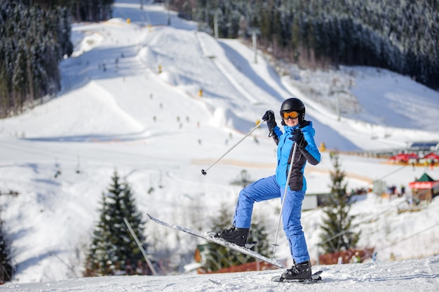 Mujer esquiadora en una pista de esquí en un día soleado