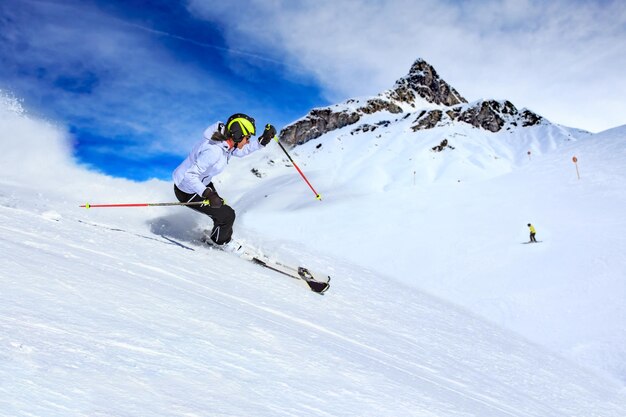 Mujer esquiando en una montaña cubierta de nieve contra el cielo