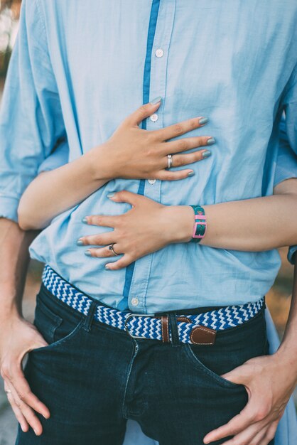 La mujer está abrazando a su hombre con las manos