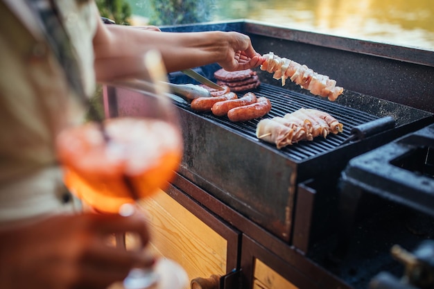 La mujer está asando una deliciosa carne en la barbacoa