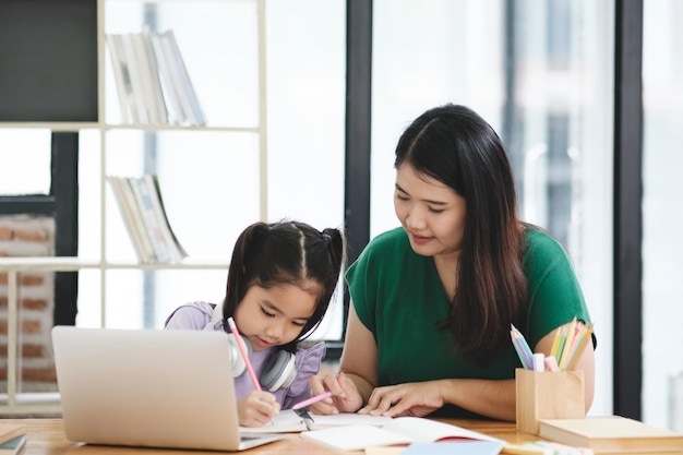 Una mujer está ayudando a una niña con su tarea