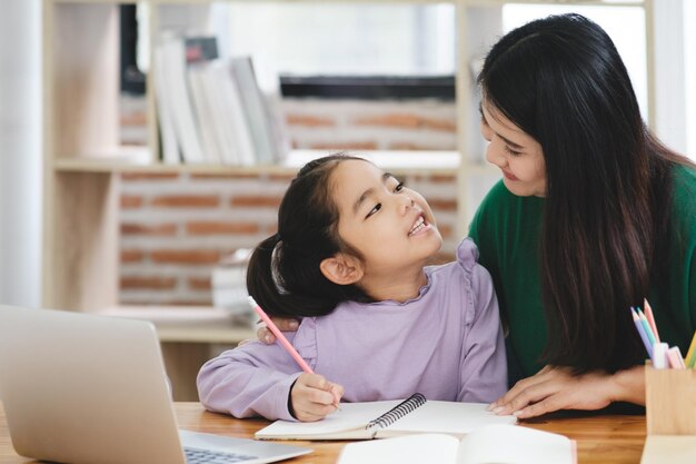 Una mujer está ayudando a una niña con su tarea