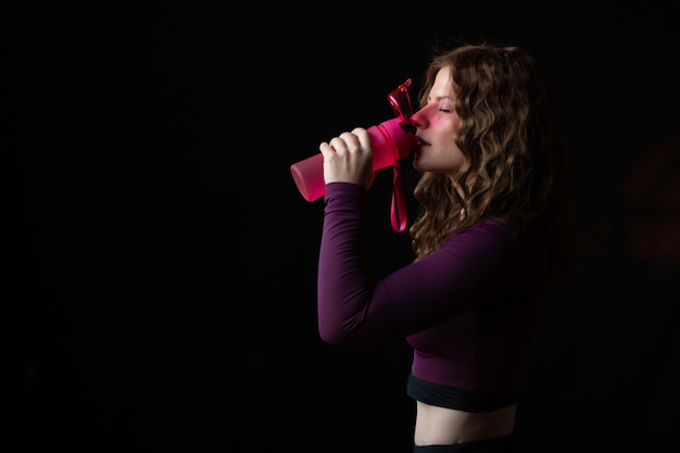 mujer está bebiendo agua después de trabajar