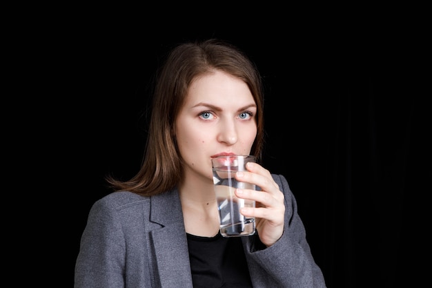 mujer está bebiendo agua pura y limpia del vaso