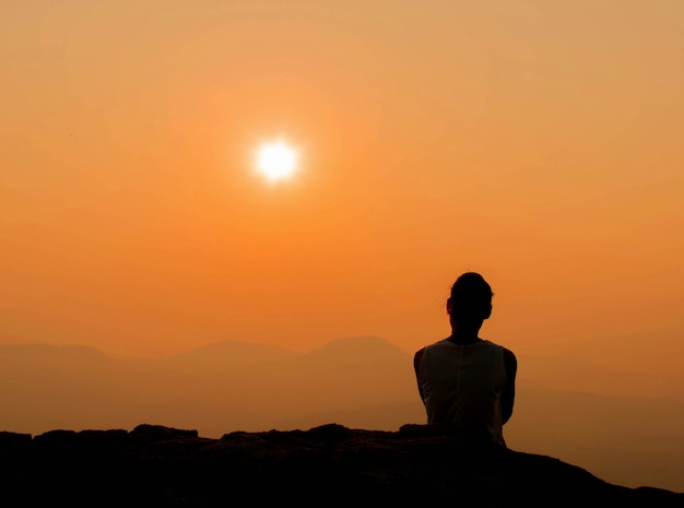 mujer está buscando un hermoso amanecer con vistas a la montaña