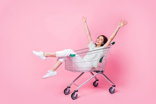 una mujer está en un carrito de compras con los brazos en el aire