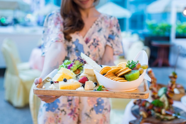 La mujer está celebrando un desayuno saludable de galletas de queso y fruta fresca.