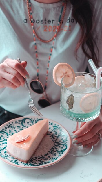 una mujer está comiendo una comida con un vaso de agua helada y una bebida