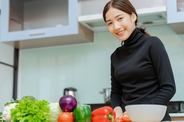 La mujer está cortando verduras para preparar la cocina