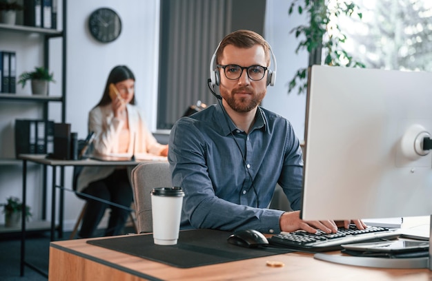 La mujer está detrás del hombre Dos empleados están trabajando juntos en la oficina moderna