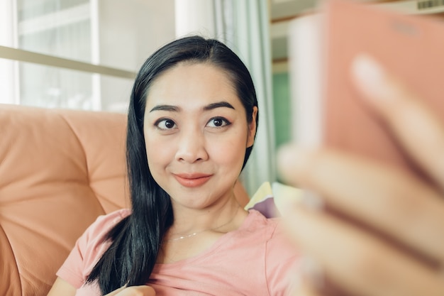 La mujer está disparando selfie con su teléfono inteligente.