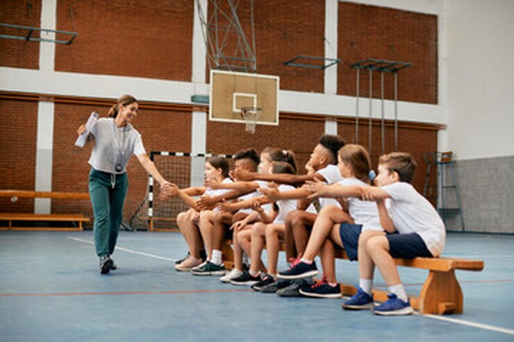 una mujer está enseñando a un grupo de niños a jugar al baloncesto