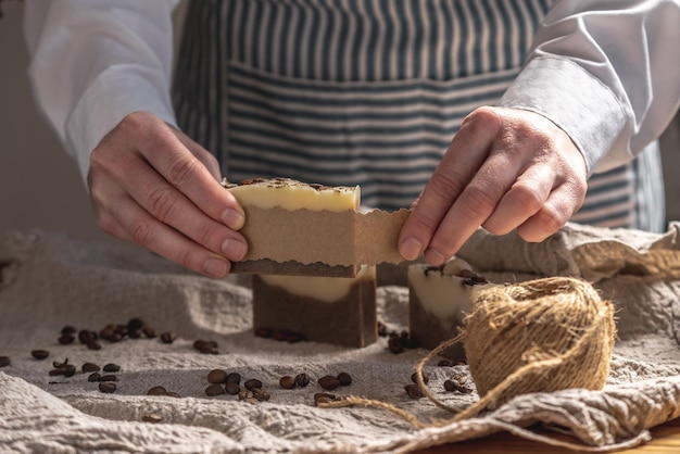 La mujer está envolviendo un hermoso jabón de café natural en papel artesanal Concepto de regalos hechos a mano pasatiempos comportamiento ecológico