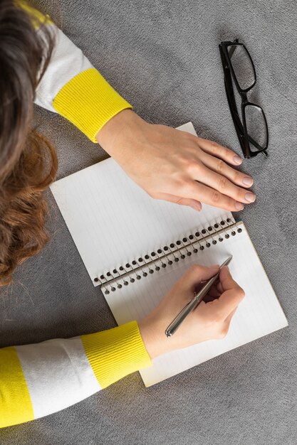 La mujer está escribiendo en el cuaderno.