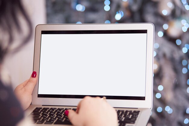 La mujer está escribiendo en el teclado de la computadora portátil Pantalla blanca de la computadora portátil de cerca en la cama Invierno acogedor hogar independiente en línea estudiando educación concepto de trabajo remoto Vista superior Copiar espacio