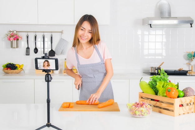 La mujer está grabando el video de cocina en la cocina.