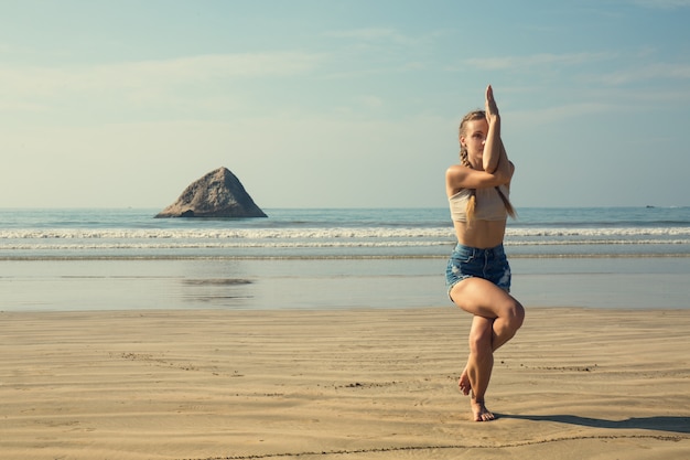 Una mujer está haciendo una asana garuda