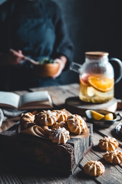 Mujer está leyendo y té caliente con pomelo fresco en tableta de madera. Bebida saludable, Eco, vegana.