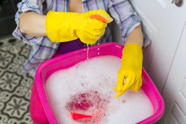 La mujer está limpiando en el baño en casa