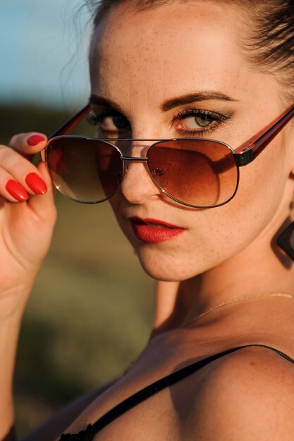 La mujer está mirando por encima de las gafas de sol