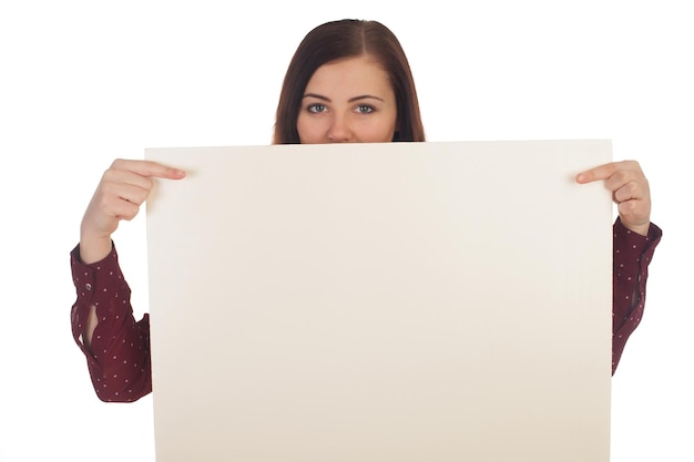 La mujer está mirando desde un lienzo en blanco