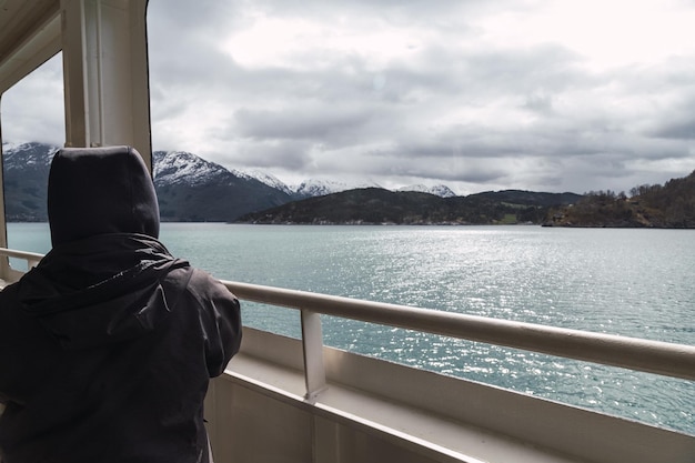 La mujer está mirando la vista del fiordo desde un barco