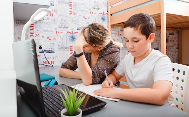 la mujer está molesta porque tiene que trabajar en casa con un niño. Educación en casa, educación a distancia, educación infantil en línea. Trabajo a distancia, trabajo autónomo.