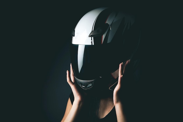 Una mujer está parada en un casco de una motocicleta.